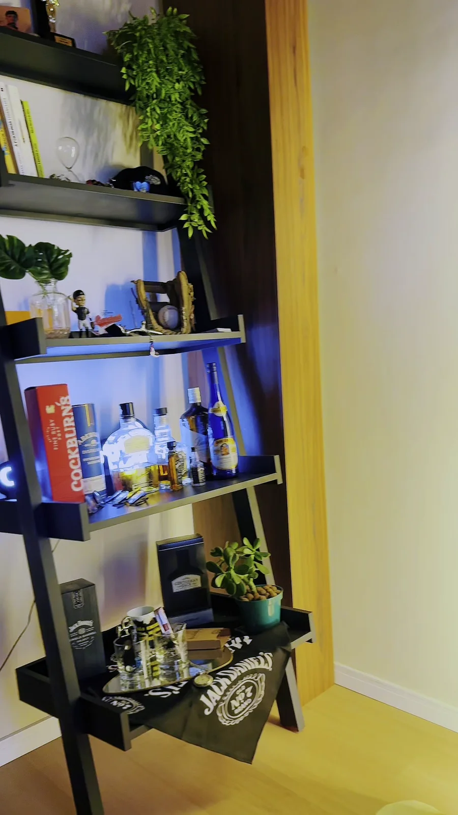 Estante com bebidas e plantas, parte da experiência de chegada.