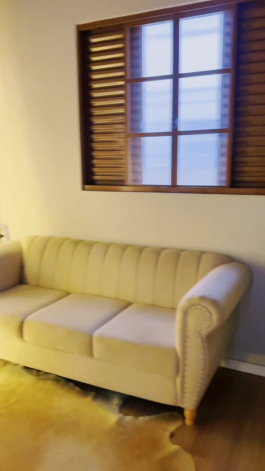 Sofá capitonê claro em um dos ambientes reservados.
